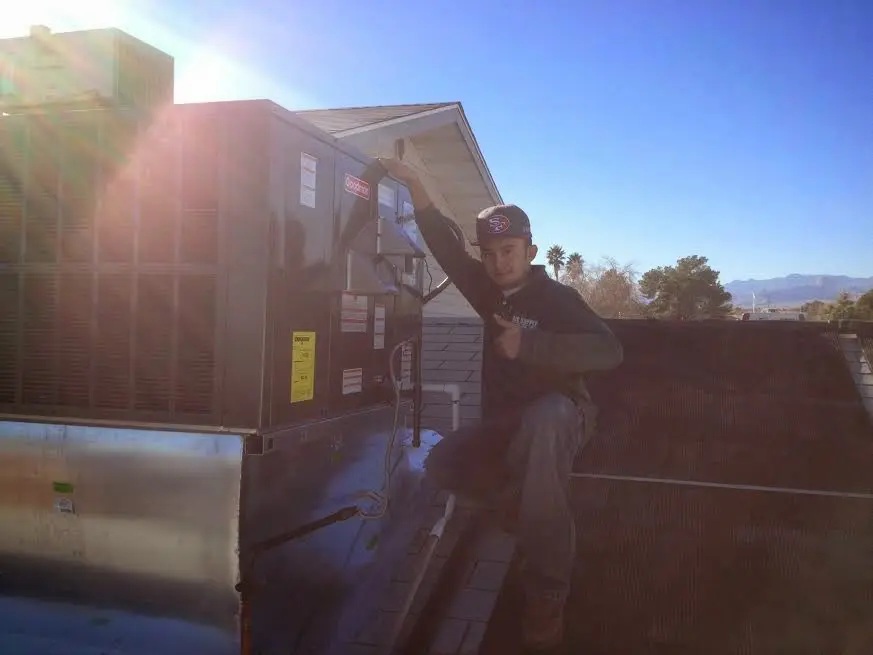 HVAC technician performing Heat Pump Repair on a rooftop unit in Sumner